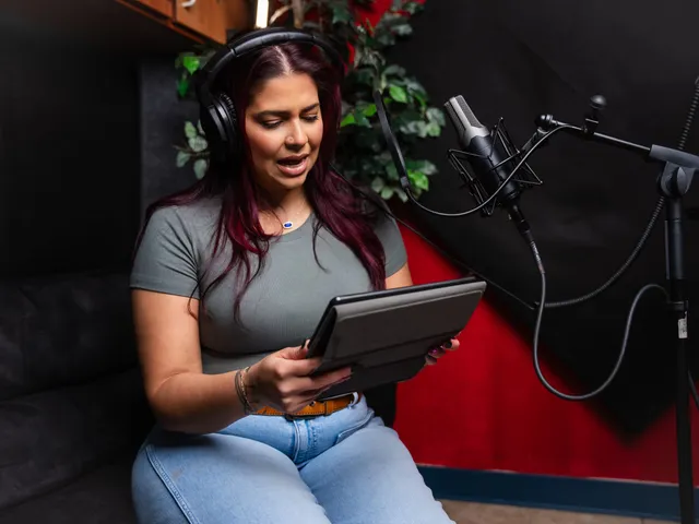 Victoria Rojas performing a line into the condenser microphone, reading from a tablet held at chest height
