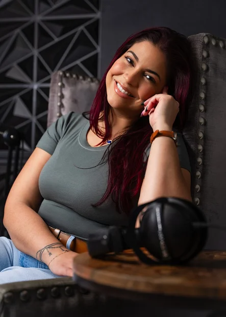 Victoria Rojas smiling in a studded armchair beside her headphones